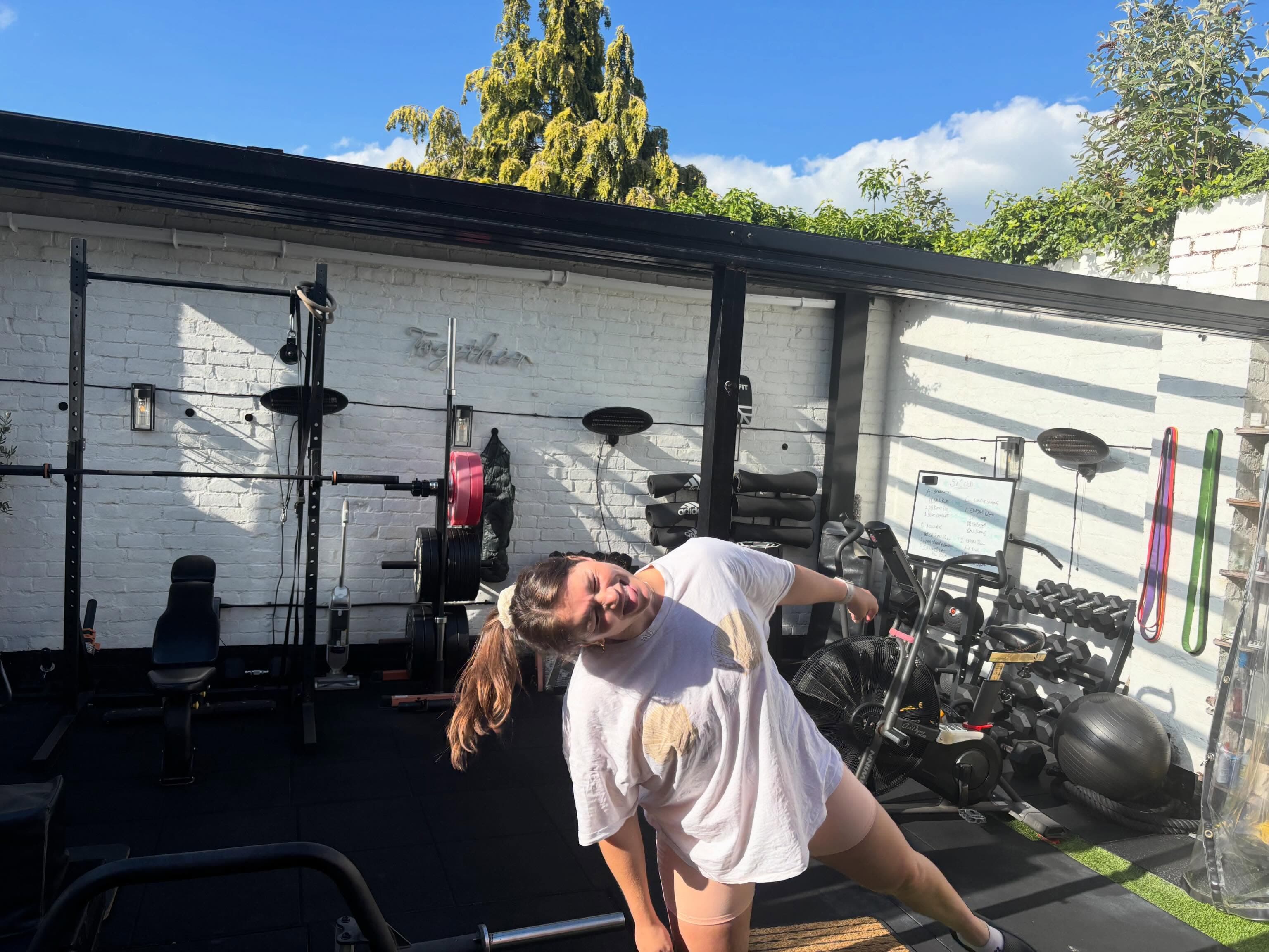 Lucy smiling inside Rose Yard Studio with the training equipment behind her